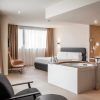 Disfrute de la comodidad moderna en el Hotel con jacuzzi SB Diagonal Zero en Barcelona, que cuenta con una lujosa cama doble, un cómodo sillón, un jacuzzi placentero y una amplia ventana con elegantes cortinas beige. - ForTwo - Planes para parejas