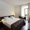 Disfrute de una estancia en Escapada Hospes Palau de la Mar en Valencia, con una moderna habitación con dos camas, zona de estar, lámparas, TV y una ventana con cortinas transparentes. Empiece el día con un desayuno y disfrute de las lujosas ofertas del spa. - ForTwo - Planes para parejas