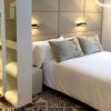 Experimente una moderna habitación de hotel con estanterías abiertas, una elegante cama, suelo estampado, apliques de pared y vistas increíbles del encanto de Barcelona con Escapada en hotel 4 estrellas. - ForTwo - Planes para parejas