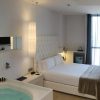 Disfrute de un remanso de paz en el Hotel con jacuzzi SB Plaza Europa (Barcelona), donde la acogedora habitación incluye una cama lujosa, iluminación relajante y cortinas transparentes que enmarcan la ventana. Relájese con estilo en su jacuzzi privado. - ForTwo - Planes para parejas