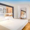 Descubra Escapada SH Inglés Boutique + desayuno en Valencia: un refugio contemporáneo con una cama grande, obras de arte cautivadoras y un cómodo sillón. La brillante iluminación realza el hermoso suelo con motivos de madera, ofreciendo el refugio ideal para una escapada perfecta. - ForTwo - Planes para parejas