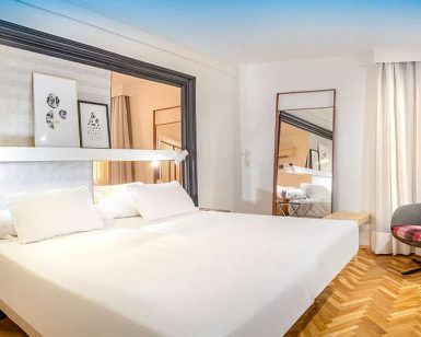 Descubra Escapada SH Inglés Boutique + desayuno en Valencia: un refugio contemporáneo con una cama grande, obras de arte cautivadoras y un cómodo sillón. La brillante iluminación realza el hermoso suelo con motivos de madera, ofreciendo el refugio ideal para una escapada perfecta. - ForTwo - Planes para parejas