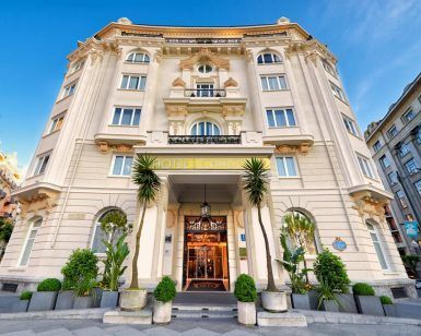 Ubicado en una exuberante vegetación, el elegante e histórico Hotel Carlton (Bilbao) cuenta con una gran entrada y ventanas arqueadas, todo ello bañado por el radiante sol de Bilbao. - ForTwo - Planes para parejas