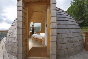 En la Selva de Irati de Navarra, los "Iglús panorámicos" ofrecen una cabaña abovedada de madera con puertas abiertas que revelan impresionantes vistas y una acogedora cama para una escapada tranquila a la naturaleza. - ForTwo - Planes para parejas