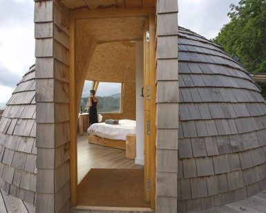 En la Selva de Irati de Navarra, los "Iglús panorámicos" ofrecen una cabaña abovedada de madera con puertas abiertas que revelan impresionantes vistas y una acogedora cama para una escapada tranquila a la naturaleza. - ForTwo - Planes para parejas