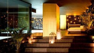 Experimente la lujosa y tenuemente iluminada zona de spa interior del Hotel de diseño 4* con spa, desayuno y cava (Granada), equipada con escaleras, linternas, plantas y una tumbona para una atmósfera relajante. - ForTwo - Planes para parejas
