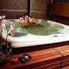 Una pareja relajada en un "Jacuzzi privado con tu pareja + cava + bombones", rodeados de orquídeas, a la luz de las velas en un banco de madera, disfrutando de cava burbujeante y deliciosos bombones. - ForTwo - Planes para parejas