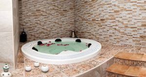 Disfrute de la Sesión de jacuzzi con masaje en Centro Natura (Toledo), donde los pétalos de rosa flotantes realzan el ambiente sereno en medio de un entorno elegantemente embaldosado. - ForTwo - Planes para parejas