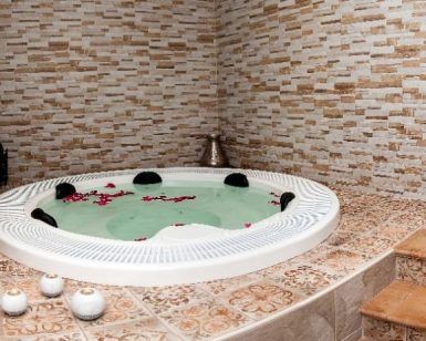 Disfrute de la Sesión de jacuzzi con masaje en Centro Natura (Toledo), donde los pétalos de rosa flotantes realzan el ambiente sereno en medio de un entorno elegantemente embaldosado. - ForTwo - Planes para parejas