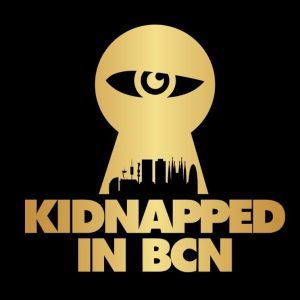 Un logo dorado con un ojo en forma de cerradura sobre el horizonte de la ciudad captura el estilo de Tarantino, con el texto "Secuestrado en BCN" en negro. Vive la experiencia "Secuestrado en BCN - Un juego a lo Tarantino de Escape Room (Barcelona)" con la vibrante Barcelona como telón de fondo. - ForTwo - Planes para parejas