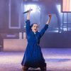 En el Teatro Lara de Madrid, una persona con un vestido azul se arrodilla con los brazos en alto y sostiene un micrófono, lo que recuerda las escenas dinámicas de "La llamada". - ForTwo - Planes para parejas