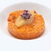 Saborea un risotto gourmet cubierto con erizo de mar y flores moradas comestibles, bellamente presentado en un plato blanco en el Restaurante Las Corchuelas Hospes Palacio de Arenales en Cáceres. - ForTwo - Planes para parejas