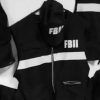 Uniformes y gorras del FBI en blanco y negro colgados en una pared evocan los emocionantes misterios de "El Registro", un juego de Lock In Escape Room (Granada). - ForTwo - Planes para parejas