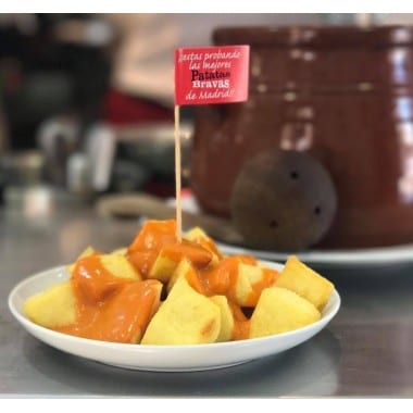 Una pila de verduras en rodajas, rociadas con aceite y hierbas, adornadas con una ramita de tomillo, resalta el arte enseñado en "Curso de Cocina Francesa: Descubre el Arte Culinario con Mélanie Dyé". - ForTwo - Planes para parejas