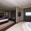 Alójese en una habitación contemporánea en el Hotel Los Peñascales: disfrute de la máxima privacidad (Madrid), que cuenta con una cama King, TV montada en la pared, zona de estar y jacuzzi junto a grandes ventanales para disfrutar de la máxima experiencia de lujo y privacidad. - ForTwo - Planes para parejas