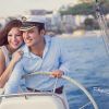 Una pareja, llena de alegría y amor por la aventura, navega en su velero cerca de la orilla en un día soleado, un momento perfecto para "Book de fotografía para parejas: Session Love". - ForTwo - Planes para parejas