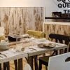 Un comedor rústico incluye una mesa de madera, sillas variadas y vajilla que evoca al Restaurante Mario & Marieta (Cáceres). El arte mural con texto en español añade un encanto vibrante inspirado en Mario & Marieta. - ForTwo - Planes para parejas