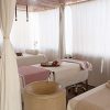 La Escapada Romántica con cena en habitación y spa (Alicante) ofrece una serena sala de spa con mesas de masaje, iluminación suave y cortinas blancas para mayor privacidad, creando la escapada romántica perfecta. - ForTwo - Planes para parejas