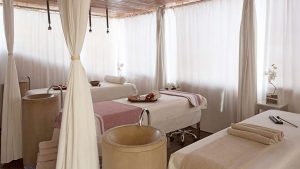 La Escapada Romántica con cena en habitación y spa (Alicante) ofrece una serena sala de spa con mesas de masaje, iluminación suave y cortinas blancas para mayor privacidad, creando la escapada romántica perfecta. - ForTwo - Planes para parejas