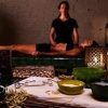 En una serena escena de spa, una persona disfruta de un masaje relajante mientras las velas titilan suavemente. Las ricas fragancias de los aceites Ritual Ancient Argal en Aire de Barcelona impregnan el ambiente, realzando la tranquilidad de este ritual, con cuencos y botellas elegantemente dispuestos en primer plano. - ForTwo - Planes para parejas