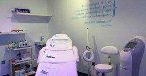 Una sala clínica con sillón de tratamiento, equipamiento y una cita en la pared ofrece serenidad en Valencia con el relajante "Masaje relajante corporal de 50 minutos (Valencia)" de 50 minutos diseñado especialmente para ti. - ForTwo - Planes para parejas