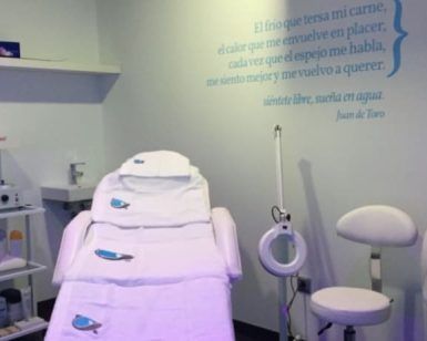 Una sala clínica con sillón de tratamiento, equipamiento y una cita en la pared ofrece serenidad en Valencia con el relajante "Masaje relajante corporal de 50 minutos (Valencia)" de 50 minutos diseñado especialmente para ti. - ForTwo - Planes para parejas