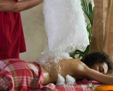 Una persona aprecia el relajante ritual de un masaje con polvos de hierbas sobre una mesa cubierta de cuadros rojos, evocando la atmósfera tranquila del Baño y Ritual Almudaina Para Dos en Hammam Al Ándalus Madrid. - ForTwo - Planes para parejas