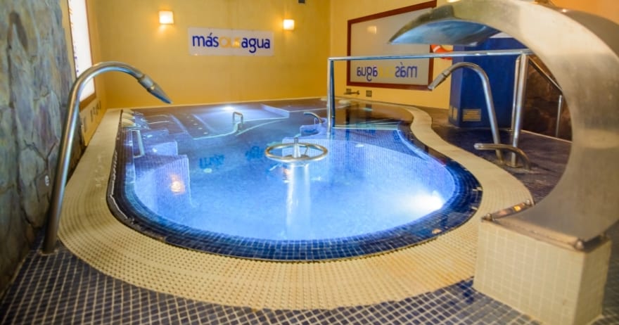 Relájese en la serena piscina cubierta con chorros de hidroterapia y azulejos azules, realzada por relajantes fuentes de agua e iluminación cálida en Circuito Termal Spa Lowcost en Madrid, que ofrece tranquilidad y rejuvenecimiento para todos los huéspedes. - ForTwo - Planes para parejas
