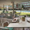 El Day pass “Pool gourmet” del Hotel Meliá Barajas (Madrid) ofrece acceso a un elegante patio exterior con mesas y sillas junto a una resplandeciente piscina, perfecto para disfrutar de comida y bebidas gourmet mientras contempla las vistas a la exuberante zona verde y al señorial edificio. - ForTwo - Planes para parejas