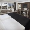 Una moderna habitación del Hotel Meliá Sol y Nieve en Sierra Nevada (Granada) incluye una cama doble, sofá, escritorio y ofrece impresionantes vistas a Sierra Nevada a través de grandes ventanales. - ForTwo - Planes para parejas
