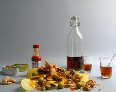 Picnic en Barcelona - Menú Aperitivo ofrece una deliciosa selección de patatas fritas, aceitunas, conservas de marisco y salsa picante. Ideal para un picnic soleado en Barcelona, incluye vasos y removedores junto a una clásica botella de cristal. - ForTwo - Planes para parejas