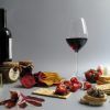 Una copa de vino, galletas, embutidos, fresas y diversos untables crean el montaje del Menú Campo con una botella de vino de fondo, ideal para un delicioso Picnic en Barcelona. - ForTwo - Planes para parejas