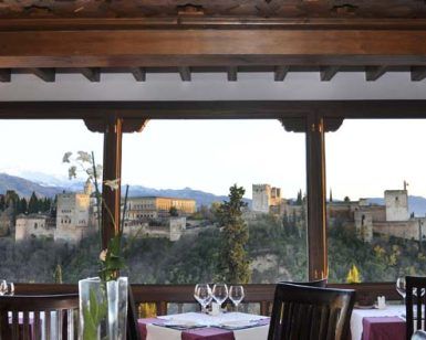 Experimenta la "Degustación para dos en el restaurante Estrellas de San Nicolás", donde podrás saborear un menú degustación con impresionantes vistas del Palacio de la Alhambra y las montañas lejanas. - ForTwo - Planes para parejas