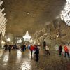 Los visitantes exploran la fascinante cámara subterránea de las minas de sal de Wieliczka, iluminada por candelabros que resaltan las paredes de piedra tallada, durante una "Visita de 4 horas a las minas de sal de Wieliczka (Cracovia). - ForTwo - Planes para parejas