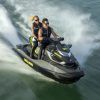 Dos personas en una "Surca las olas de Barcelona en moto acuática" navegan rápidamente sobre el agua, creando un chapoteo tras de sí. - ForTwo - Planes para parejas