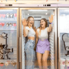Dos mujeres ríen dentro de una gran nevera adornada con divertidas calcomanías de dibujos animados y envases de helado en el peculiar Museo Sweet Space de Madrid. ¡Compra tus "Entradas al Museo Sweet Space de Madrid" para vivir una experiencia encantadora!. - ForTwo - Planes para parejas