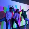 Tres personas en poses divertidas frente a un fondo colorido y lleno de sombras en el Museo de las Ilusiones de Sevilla. - ForTwo - Planes para parejas