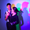 En el Museo de las Ilusiones de Madrid, una pareja posa juguetonamente, creando sombras de colores bajo luces rosas, azules y verdes. ¡Reserva ya tus entradas al Museo de las Ilusiones de Madrid para disfrutar de esta vibrante experiencia!. - ForTwo - Planes para parejas
