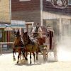 Una diligencia tirada por dos caballos recorre un polvoriento pueblo del Oeste, que recuerda a Oasys, el parque temático del desierto de Tabernas (Almería). Ofrece una vívida mirada al pasado sin necesidad de entradas. - ForTwo - Planes para parejas