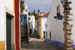 Explore las encantadoras calles adoquinadas, los edificios encalados, las puertas coloridas y las escaleras en el pintoresco pueblo de Óbidos en nuestra "Visita guiada a Óbidos y Fátima (Lisboa). - ForTwo - Planes para parejas