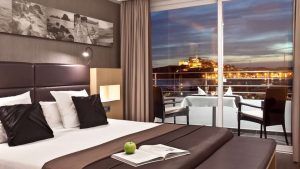 Disfrute de una moderna habitación de hotel con una cama grande, impresionantes vistas de la ciudad y cenas en el balcón al atardecer. Viva una escapada inolvidable con la "Escapada OD Ocean Drive con desayuno (Ibiza)", donde la elegancia se fusiona con vistas impresionantes. - ForTwo - Planes para parejas
