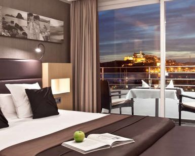 Disfrute de una moderna habitación de hotel con una cama grande, impresionantes vistas de la ciudad y cenas en el balcón al atardecer. Viva una escapada inolvidable con la "Escapada OD Ocean Drive con desayuno (Ibiza)", donde la elegancia se fusiona con vistas impresionantes. - ForTwo - Planes para parejas