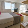 Experimente el encanto moderno de One Ibiza Suites (Ibiza), que cuenta con habitaciones con camas grandes, detalles en rosa, televisores, estantes y un fascinante balcón con vista al mar. - ForTwo - Planes para parejas