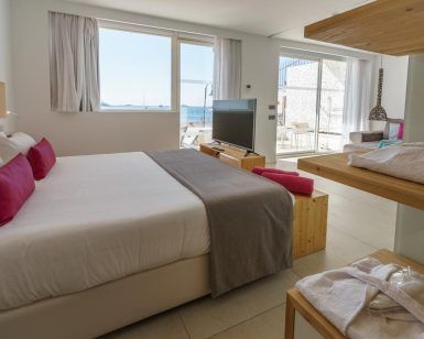 Experimente el encanto moderno de One Ibiza Suites (Ibiza), que cuenta con habitaciones con camas grandes, detalles en rosa, televisores, estantes y un fascinante balcón con vista al mar. - ForTwo - Planes para parejas