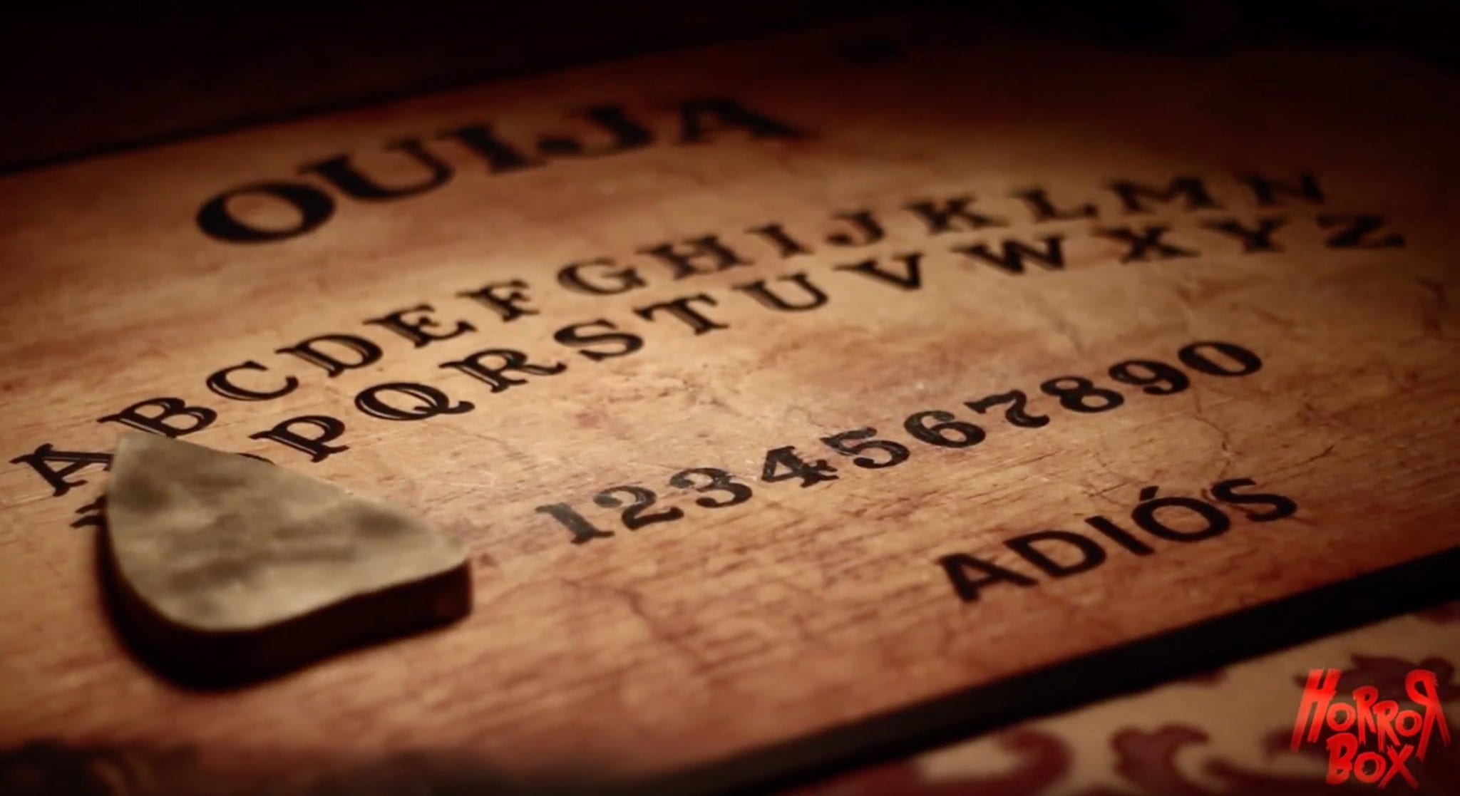 Un primer plano de la ouija de "Ouija - Un juego de Horror Box Escape Room (Barcelona)" presenta una plancheta, capturando la atmósfera inquietante de una sala de escape. El logo de Horror Box se esconde en una esquina, realzando la atmósfera escalofriante. - ForTwo - Planes para parejas