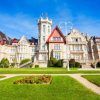 Explora la Visita al Palacio de la Magdalena en Santander, donde la arquitectura elaborada se combina con exuberantes jardines verdes bajo un cielo azul claro. - ForTwo - Planes para parejas