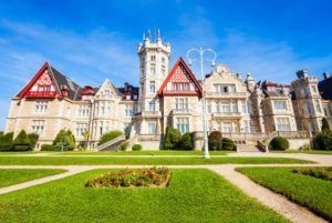 Explora la Visita al Palacio de la Magdalena en Santander, donde la arquitectura elaborada se combina con exuberantes jardines verdes bajo un cielo azul claro. - ForTwo - Planes para parejas
