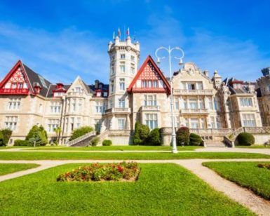 Explora la Visita al Palacio de la Magdalena en Santander, donde la arquitectura elaborada se combina con exuberantes jardines verdes bajo un cielo azul claro. - ForTwo - Planes para parejas