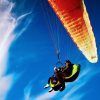 Parapentes biplaza bajo un dosel naranja se deslizan a través de tenues nubes y un cielo azul intenso cerca de la pintoresca ciudad de Vejer en Cádiz, experimentando el "Vuelo en parapente biplaza en Vejer (Cádiz). - ForTwo - Planes para parejas