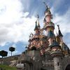 Un majestuoso castillo rosa con torres se yergue orgulloso bajo un cielo azul salpicado de nubes esponjosas, que recuerda una escena sacada directamente de una excursión a Disneyland París desde París. - ForTwo - Planes para parejas